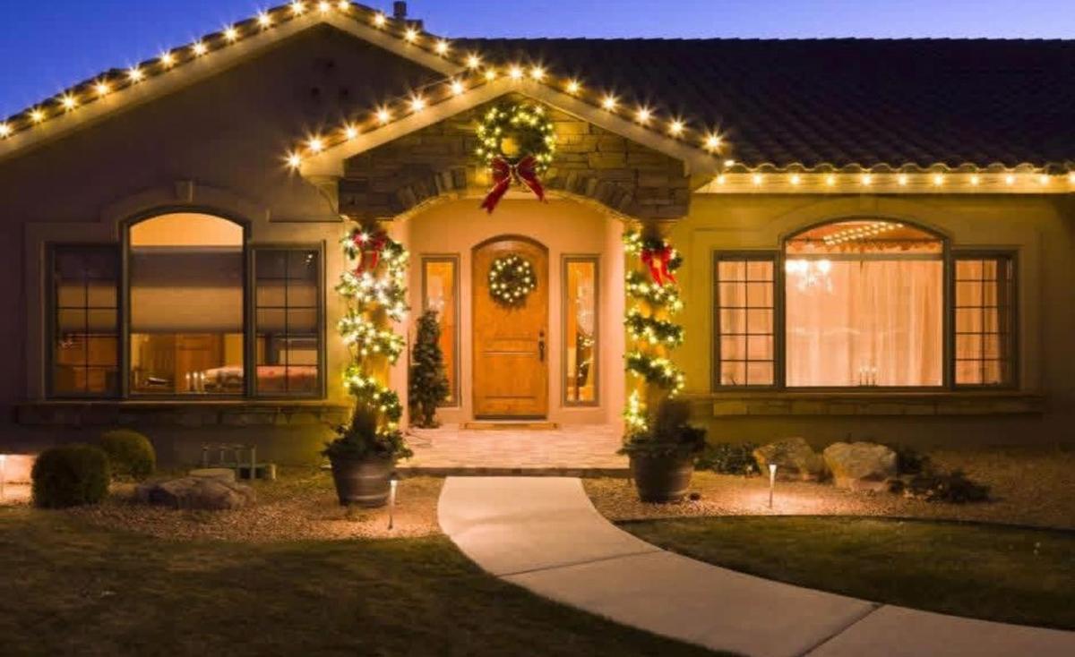 Front entry with lit garland, wreath and warm white roofline