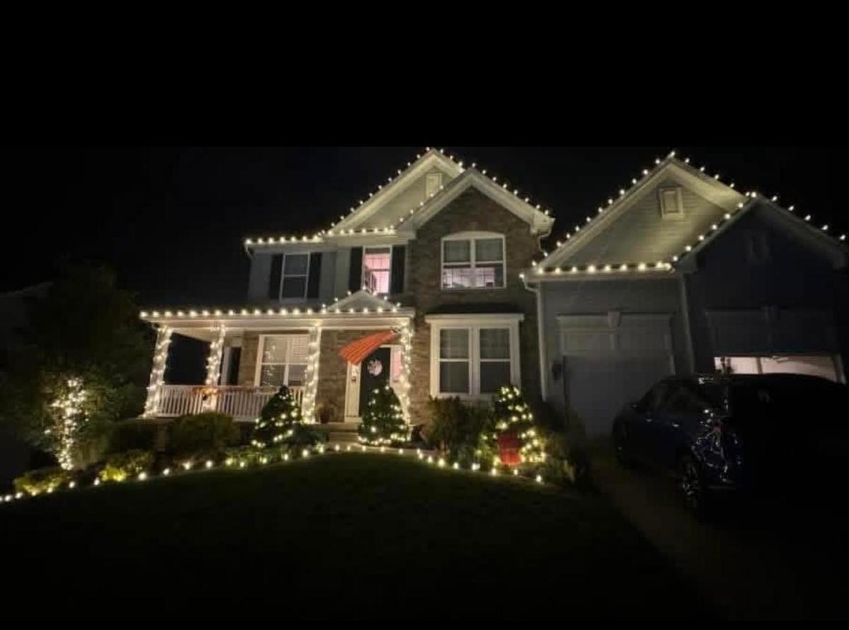 Two-story home with warm white roofline, porch and walkway lights